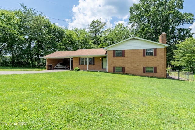 898 W Cunningham St, Alcoa, TN 37701 - tri-level home featuring concrete driveway, a chimney, a carport, brick siding, and view of scattered trees