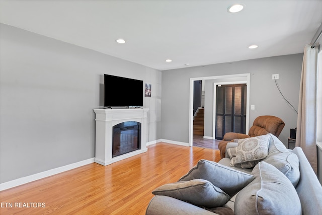 898 W Cunningham St, Alcoa, TN 37701 - living room with recessed lighting, light wood-style floors, a glass covered fireplace, and stairs