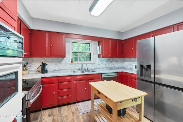 898 W Cunningham St, Alcoa, TN 37701 - kitchen with stainless steel appliances, red cabinetry, and light wood-style floors