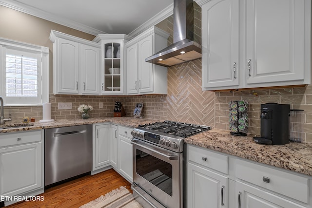 920 Andover View Ln, Knoxville, TN 37922 - kitchen with wall chimney exhaust hood, stainless steel appliances, white cabinetry, glass insert cabinets, and ornamental molding