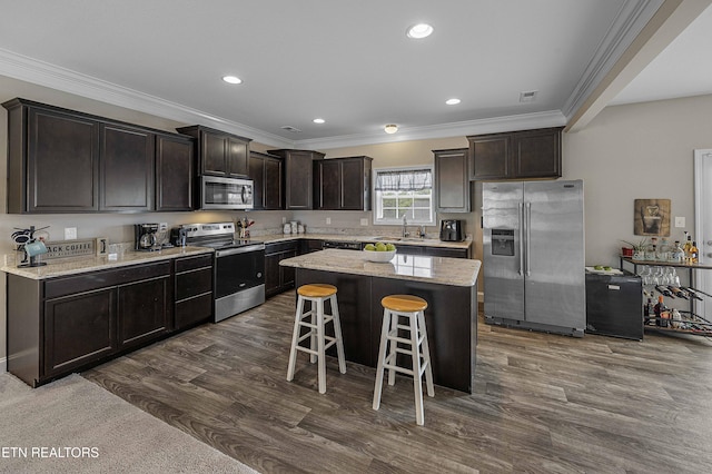 3038 Lazy River Dr, Knoxville, TN 37931 - kitchen featuring stainless steel appliances, ornamental molding, dark brown cabinetry, a breakfast bar, and a center island