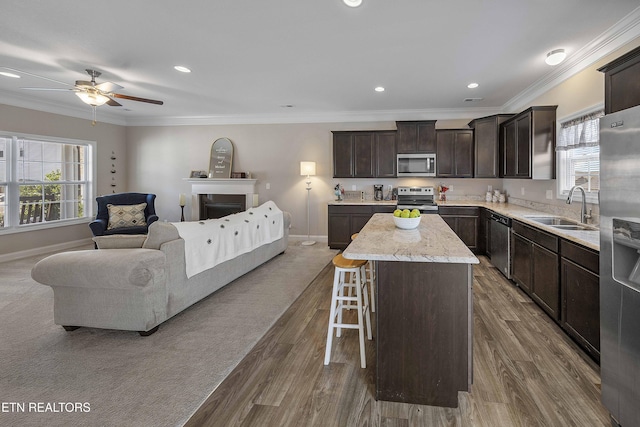 3038 Lazy River Dr, Knoxville, TN 37931 - kitchen with appliances with stainless steel finishes, open floor plan, a center island, dark brown cabinetry, and a breakfast bar area