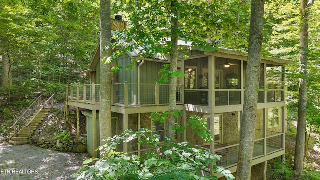 2991 Walden Flats Way, Sevierville, TN 37862 - back of house with a sunroom, stone siding, a chimney, stairs, and a wooden deck