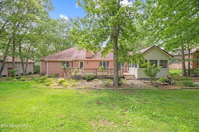 103 Wickham Ln, Fairfield Glade, TN 38558 - back of property with a yard, a wooden deck, brick siding, a chimney, and a sunroom