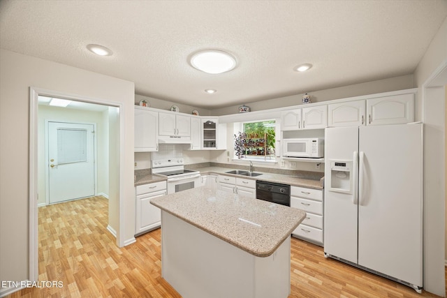 103 Wickham Ln, Fairfield Glade, TN 38558 - kitchen featuring white appliances, under cabinet range hood, white cabinetry, light wood finished floors, and a kitchen island