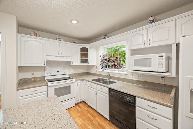 103 Wickham Ln, Fairfield Glade, TN 38558 - kitchen featuring white appliances, under cabinet range hood, light wood-style flooring, white cabinetry, and a textured ceiling