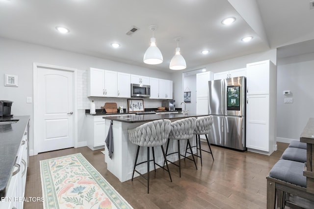 9401 Shirley Ann Rd, Kodak, TN 37764 - kitchen with stainless steel appliances, dark countertops, a kitchen bar, white cabinetry, and pendant lighting
