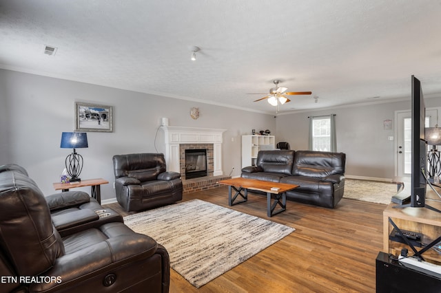 8306 Foxworth Trl, Powell, TN 37849 - living room with ceiling fan, wood finished floors, a fireplace, ornamental molding, and a textured ceiling