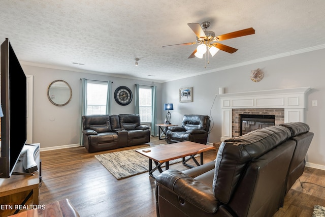 8306 Foxworth Trl, Powell, TN 37849 - living room with ceiling fan, wood finished floors, crown molding, a textured ceiling, and a brick fireplace
