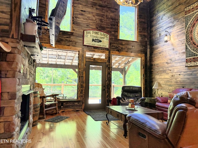 1659 Cherohala Skwy, Tellico Plains, TN 37385 - living area with wood walls, hardwood / wood-style floors, a fireplace, and a high ceiling