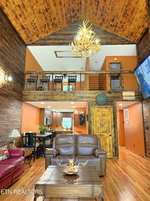 1659 Cherohala Skwy, Tellico Plains, TN 37385 - living room featuring high vaulted ceiling, wood walls, light wood-style floors, a chandelier, and wood ceiling