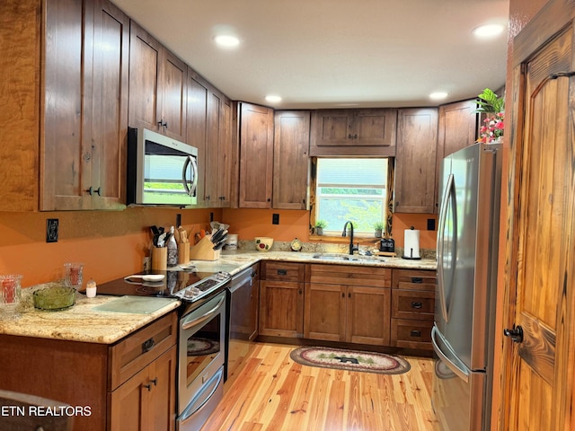 1659 Cherohala Skwy, Tellico Plains, TN 37385 - kitchen with stainless steel appliances, light wood-style flooring, recessed lighting, brown cabinets, and light stone counters