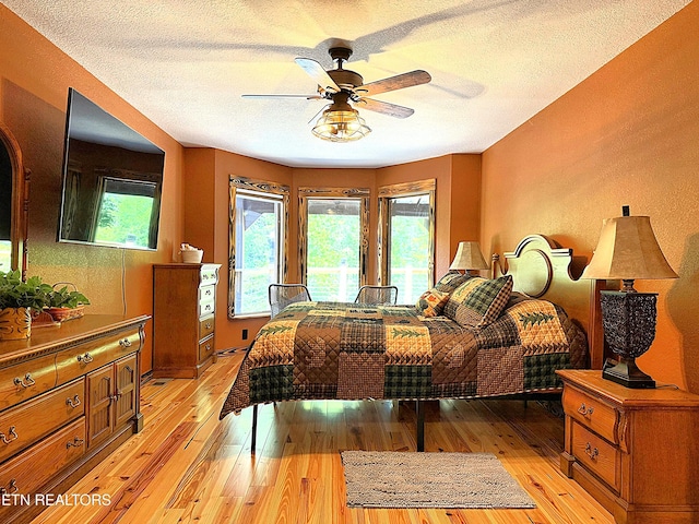 1659 Cherohala Skwy, Tellico Plains, TN 37385 - bedroom with light wood-type flooring, a textured ceiling, access to exterior, and a ceiling fan