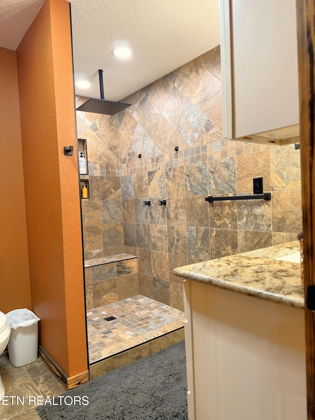 1659 Cherohala Skwy, Tellico Plains, TN 37385 - bathroom with tiled shower, vanity, a textured ceiling, and recessed lighting