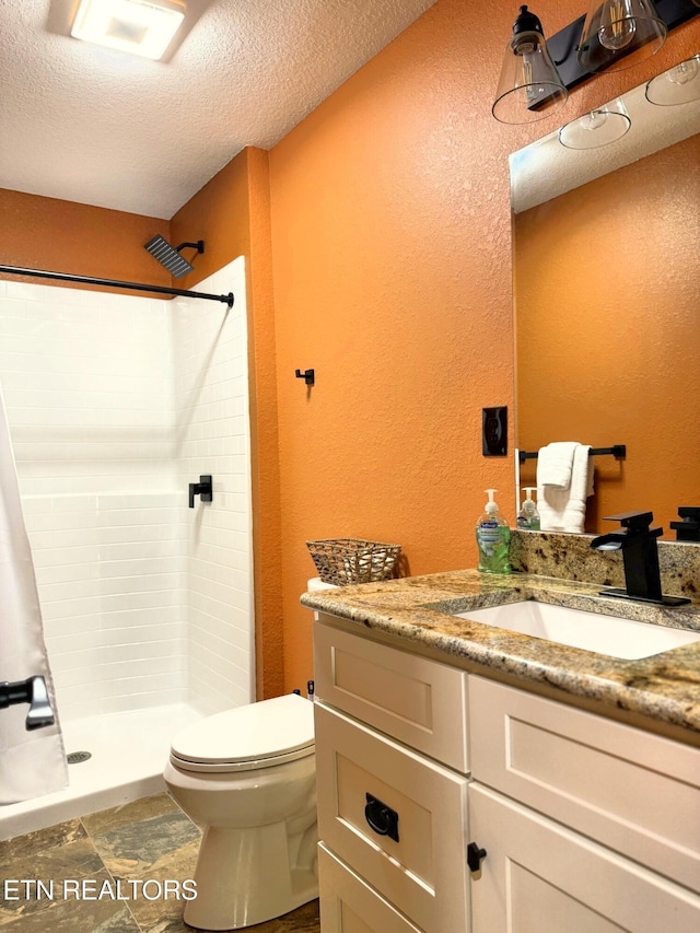 1659 Cherohala Skwy, Tellico Plains, TN 37385 - bathroom featuring a textured wall, vanity, tiled shower, and a textured ceiling