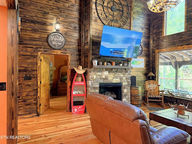 1659 Cherohala Skwy, Tellico Plains, TN 37385 - living area with wood walls, a high ceiling, wood-type flooring, a fireplace, and a chandelier