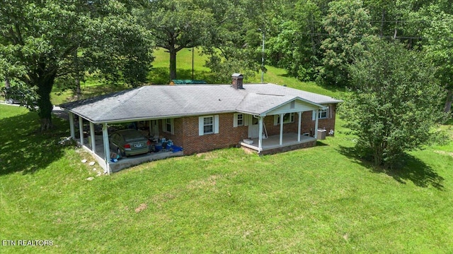 330 Dilbeck Ln, Caryville, TN 37714 - back of property featuring covered porch, a yard, an attached carport, and brick siding