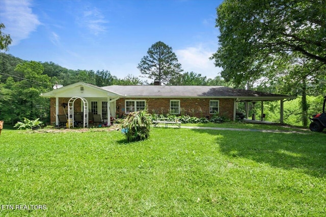 330 Dilbeck Ln, Caryville, TN 37714 - rear view of property with a yard, brick siding, and an attached carport