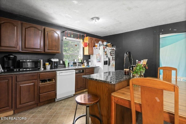 330 Dilbeck Ln, Caryville, TN 37714 - kitchen featuring white appliances, a textured ceiling, a kitchen breakfast bar, and a center island