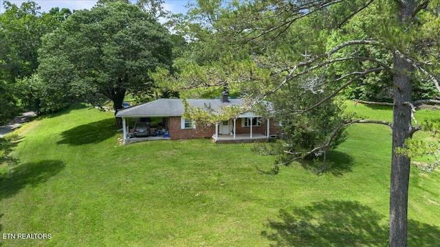 330 Dilbeck Ln, Caryville, TN 37714 - view of front of home with a front lawn, a carport, covered porch, and a chimney