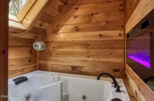 315 Greenwood Way, Pigeon Forge, TN 37863 - bathroom featuring wood walls, a skylight, and a jetted tub