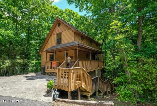 315 Greenwood Way, Pigeon Forge, TN 37863 - view of front of home with stairway, covered porch, and a forest view