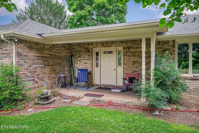 1790 Coon Hunt Rd, Baxter, TN 38544 - property entrance with brick siding, roof with shingles, and covered porch