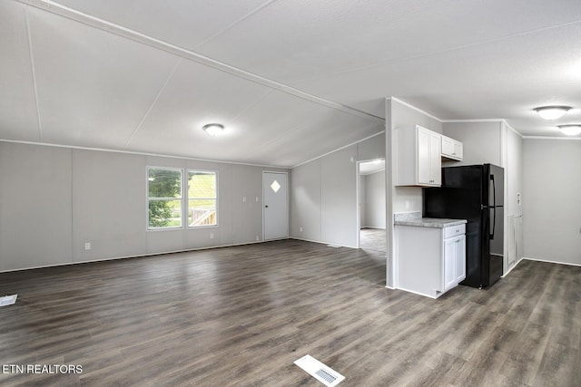 6952 Cottonport Rd, Decatur, TN 37322 - kitchen featuring freestanding refrigerator, dark wood-type flooring, white cabinetry, open floor plan, and lofted ceiling