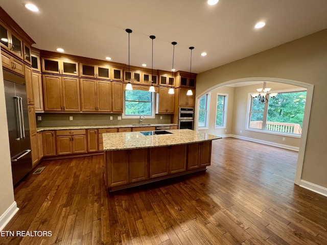2005 River Mist Cir, New Market, TN 37820 - kitchen featuring appliances with stainless steel finishes, a chandelier, arched walkways, a kitchen island, and dark wood-type flooring
