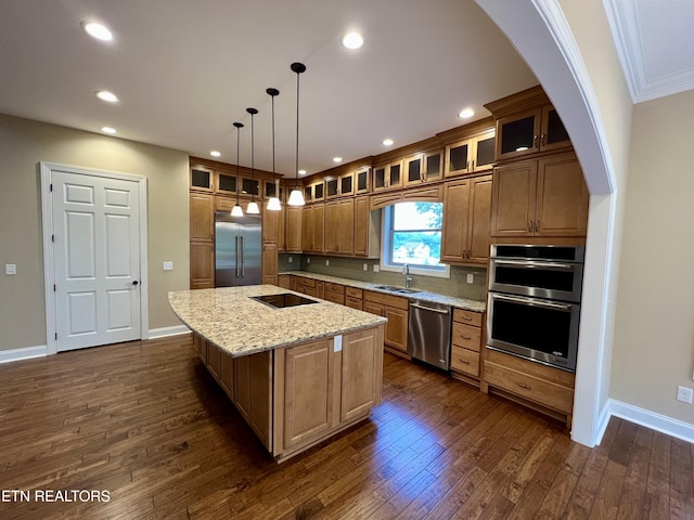 2005 River Mist Cir, New Market, TN 37820 - kitchen featuring appliances with stainless steel finishes, dark wood finished floors, a kitchen island with sink, light stone counters, and recessed lighting