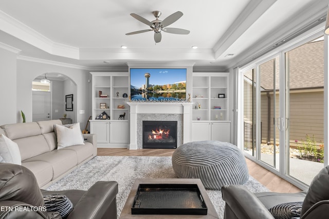 402 Sycamore Pl, Loudon, TN 37774 - living room with a tray ceiling, light wood finished floors, arched walkways, ornamental molding, and ceiling fan