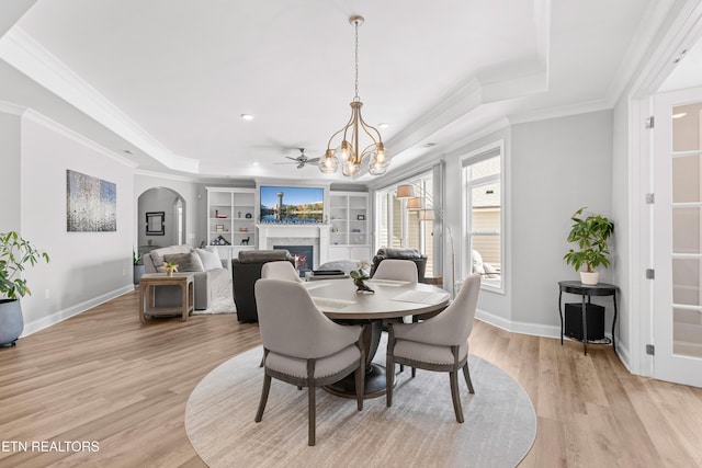 402 Sycamore Pl, Loudon, TN 37774 - dining area with a tray ceiling, a warm lit fireplace, ornamental molding, a chandelier, and light wood finished floors
