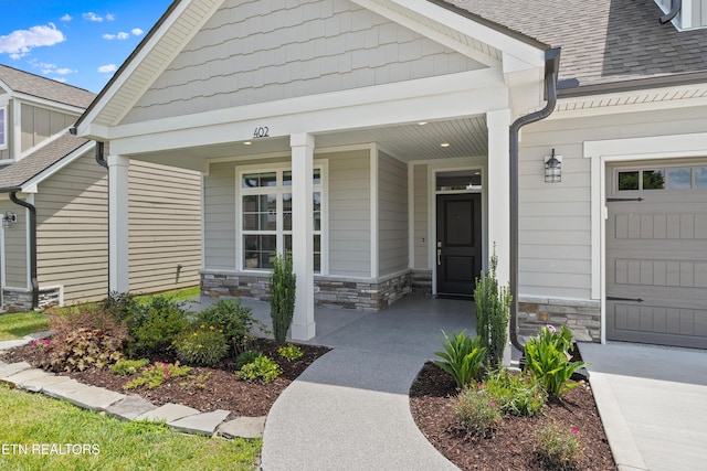 402 Sycamore Pl, Loudon, TN 37774 - view of exterior entry with covered porch, stone siding, and roof with shingles