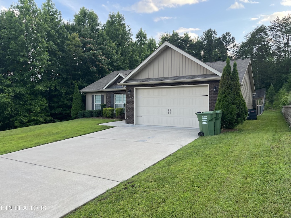 6933 Harvest Grove Ln, Knoxville, TN 37918 - ranch-style home featuring board and batten siding, an attached garage, brick siding, a front lawn, and concrete driveway