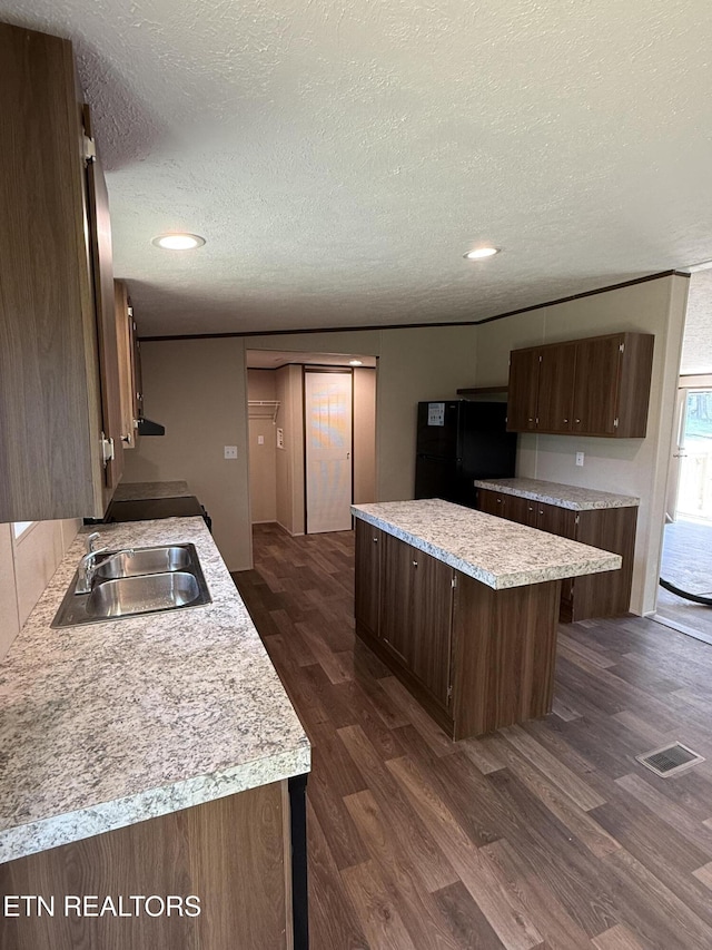 1684 Shields Dr, Morristown, TN 37814 - kitchen featuring freestanding refrigerator, dark wood-type flooring, a textured ceiling, a center island, and light countertops