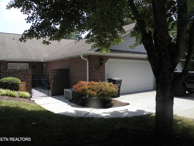 715 Cedar Ln Unit 135, Knoxville, TN 37912 - view of side of home with brick siding, a garage, concrete driveway, and roof with shingles