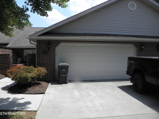 715 Cedar Ln Unit 135, Knoxville, TN 37912 - view of side of home featuring brick siding, concrete driveway, and an attached garage