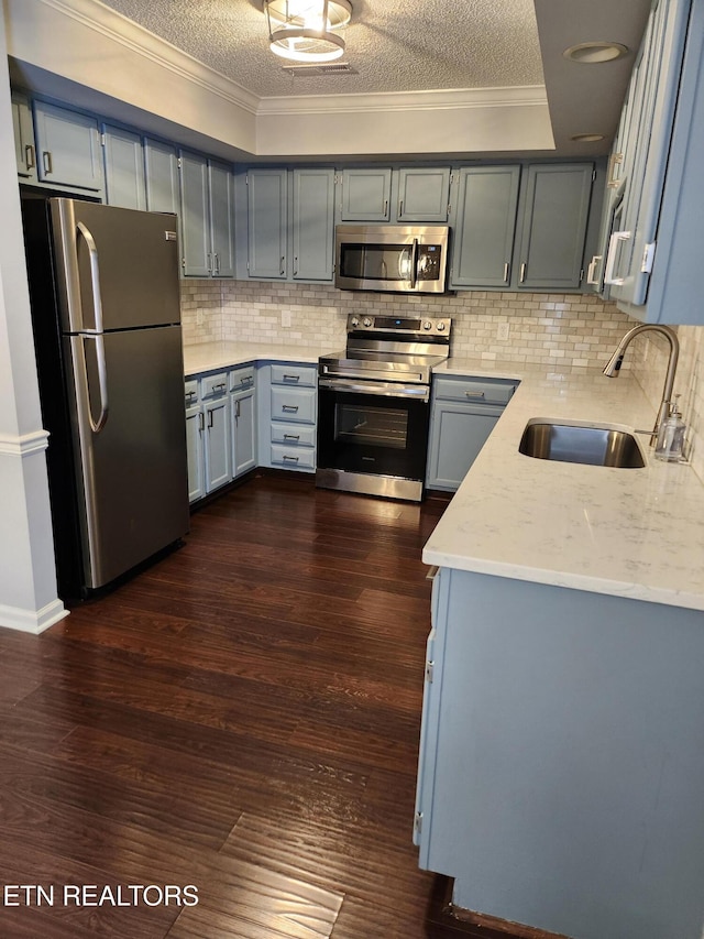 715 Cedar Ln Unit 135, Knoxville, TN 37912 - kitchen featuring appliances with stainless steel finishes, a textured ceiling, decorative backsplash, crown molding, and dark wood finished floors