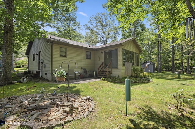122 Glenwood Dr, Crossville, TN 38555 - view of front of house with entry steps, a storage unit, and a front lawn