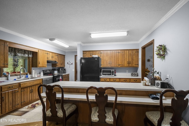 122 Glenwood Dr, Crossville, TN 38555 - kitchen featuring black appliances, under cabinet range hood, brown cabinetry, light countertops, and a textured ceiling