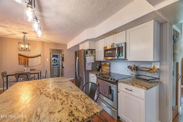 1839 Plumb Creek Cir, Knoxville, TN 37932 - kitchen featuring stainless steel appliances, a chandelier, dark wood-style flooring, a textured ceiling, and decorative backsplash