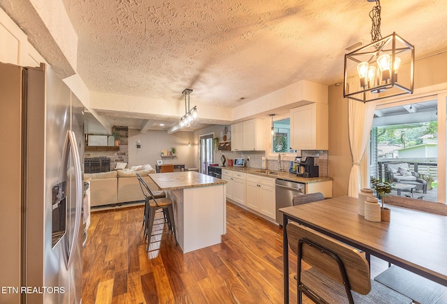 1839 Plumb Creek Cir, Knoxville, TN 37932 - kitchen with stainless steel appliances, a textured ceiling, dark wood finished floors, white cabinets, and open floor plan