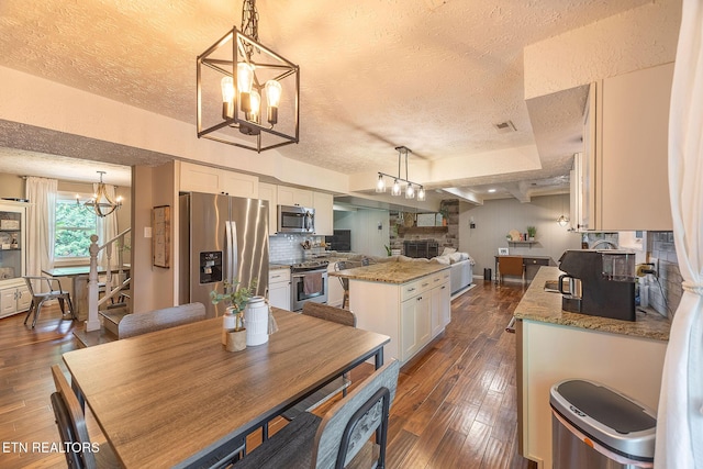 1839 Plumb Creek Cir, Knoxville, TN 37932 - dining room featuring a chandelier, a textured ceiling, dark wood-type flooring, stairway, and a fireplace