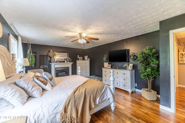 1839 Plumb Creek Cir, Knoxville, TN 37932 - bedroom featuring wood finished floors, a textured ceiling, a ceiling fan, and a fireplace