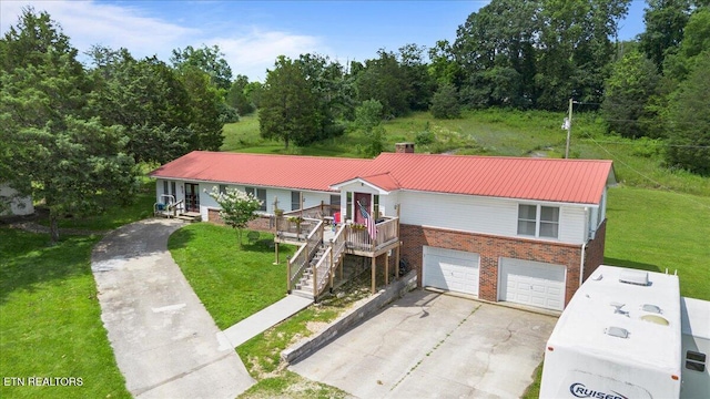 288 Forks Grove Rd, Lafollette, TN 37766 - view of front facade with brick siding, a garage, concrete driveway, a front yard, and a chimney