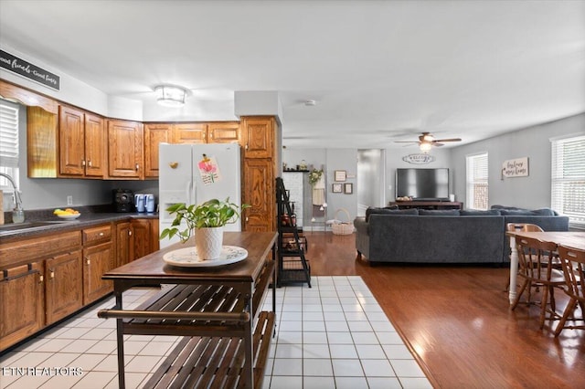 288 Forks Grove Rd, Lafollette, TN 37766 - kitchen with freestanding refrigerator, brown cabinets, ceiling fan, dark countertops, and light wood-type flooring
