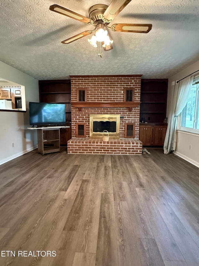 195 Hamblin St, New Tazewell, TN 37825 - unfurnished living room featuring wood finished floors, a textured ceiling, ceiling fan, and a fireplace