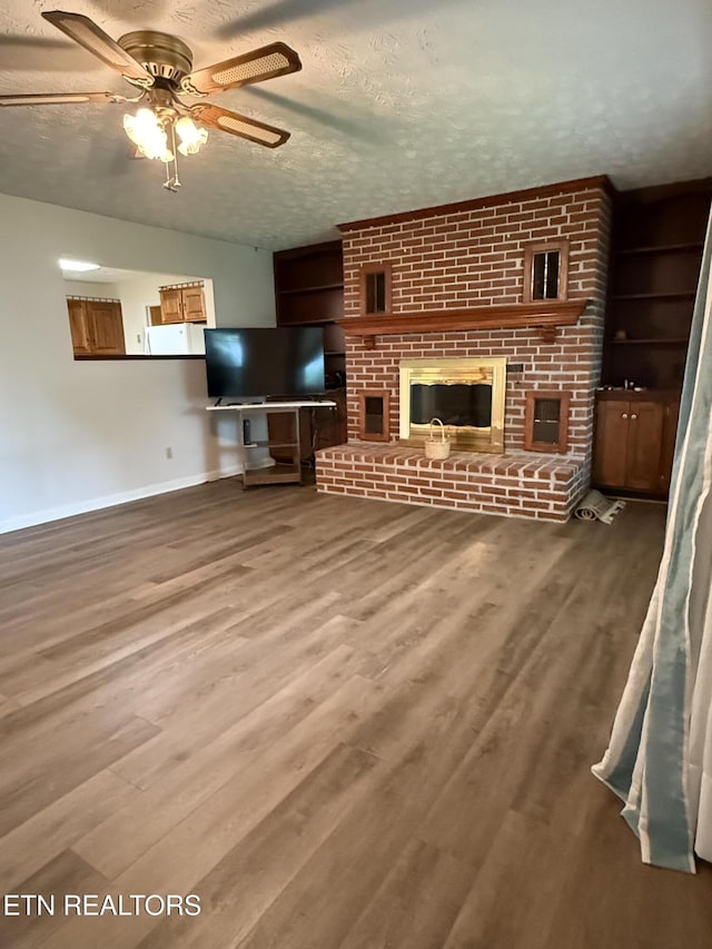 195 Hamblin St, New Tazewell, TN 37825 - unfurnished living room featuring a ceiling fan, wood finished floors, a fireplace, and a textured ceiling