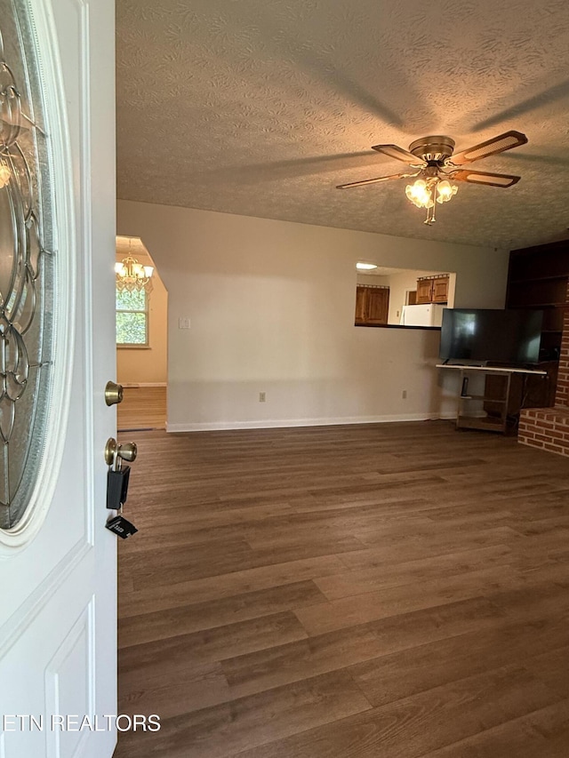 195 Hamblin St, New Tazewell, TN 37825 - unfurnished living room featuring wood finished floors, ceiling fan, a textured ceiling, and a chandelier
