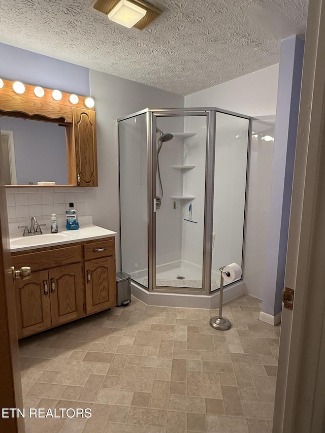 195 Hamblin St, New Tazewell, TN 37825 - full bathroom featuring a stall shower, vanity, tasteful backsplash, and a textured ceiling